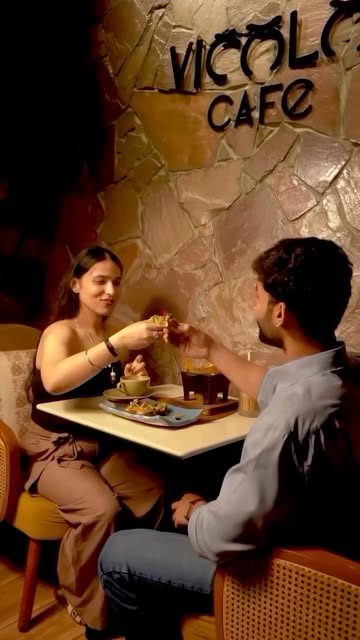 Two guests sharing a meal under the Vicolo Cafe sign