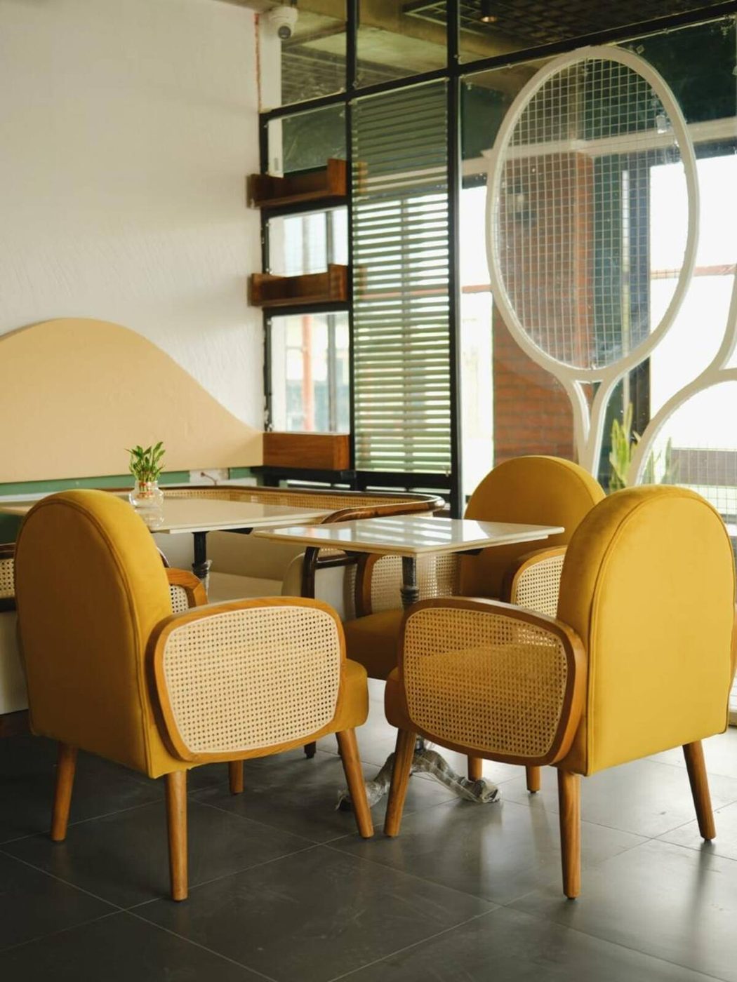 Mustard armchairs with cane backs by a sunlit arched window