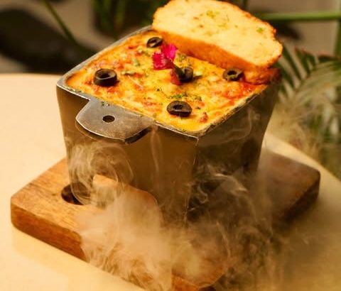 Classic verdure lasagna served smoking on a wooden board