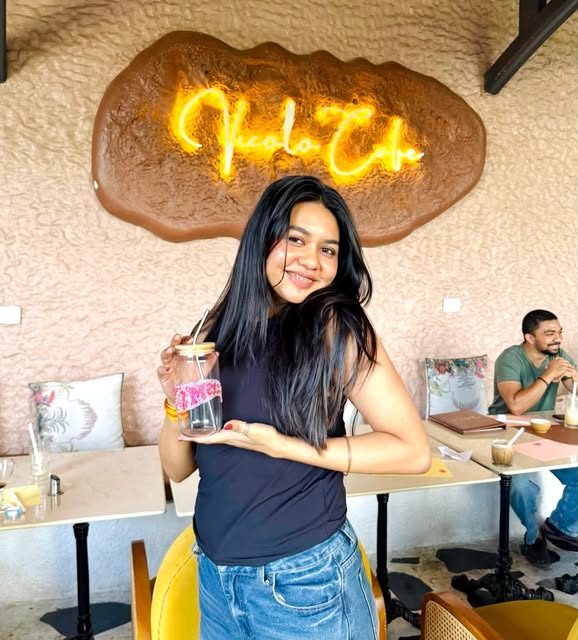 Guest holding a drink in front of the glowing Vicolo neon sign