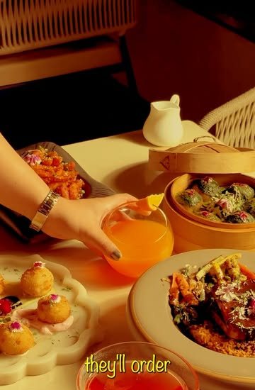 A spread of dumplings, plated starters and a mocktail on a table